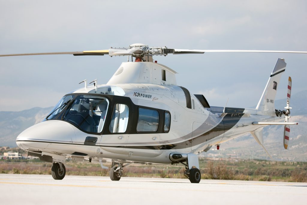 An image of a white single-bladed private helicopter landing